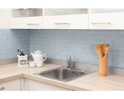 Küchenszene mit Spüle, Armatur, Geschirr und Küchenutensilien