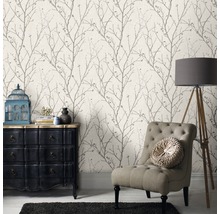 Wohnzimmer mit gemusterter Tapete, Sessel, Kommode und Stehlampe