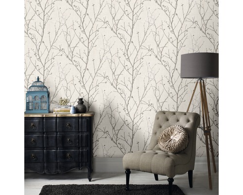 Wohnzimmer mit gemusterter Tapete, Sessel, Kommode und Stehlampe