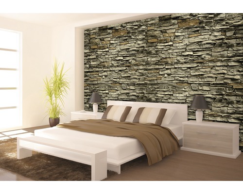 Schlafzimmer mit Steinwandtapete, Bett und Nachttischen