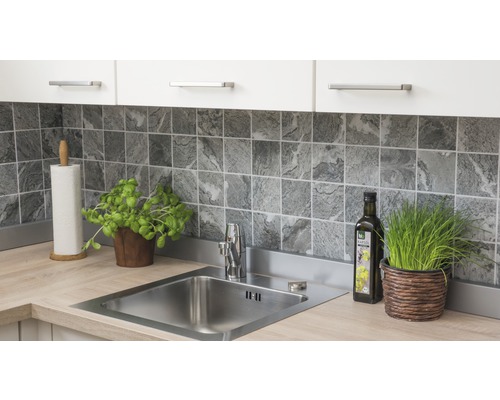 Scène de cuisine avec évier, robinet, carrelage et ustensiles de cuisine