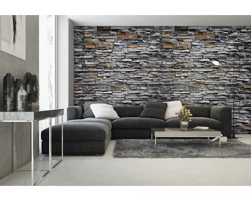 Salon avec papier peint imitation pierre, canapé, tapis et table basse.