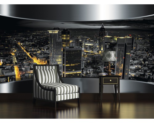 Wandbild mit Stadtansicht bei Nacht, Sessel mit Streifenmuster und Nachttisch mit Lampe in einem Raum.