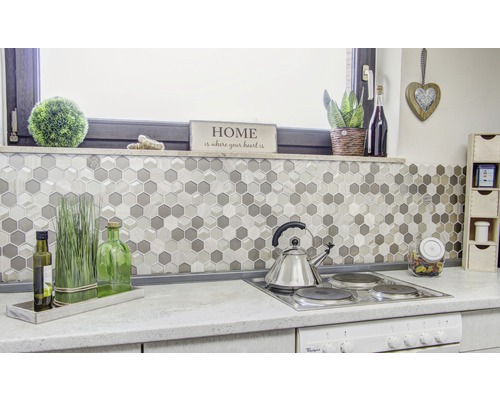 Scène de cuisine avec des carreaux de mosaïque en nid d''abeille, une plaque de cuisson et des décorations.