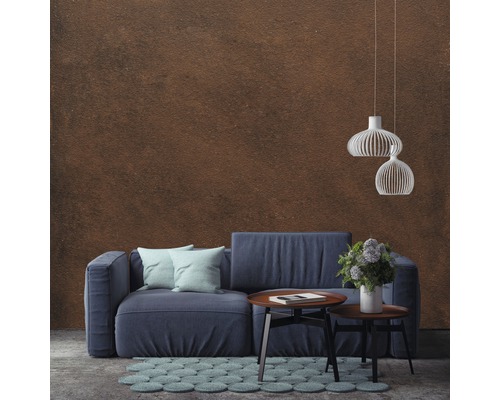 Salon avec un canapé bleu, une table basse, un tapis et des suspensions devant un mur