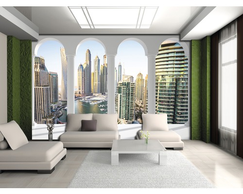 Salon lumineux avec canapé, tapis et vue panoramique sur la ville.