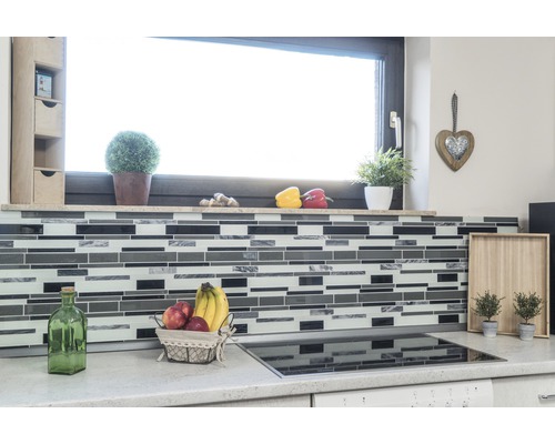 Scène de cuisine avec des carreaux de mosaïque, des fruits et des décorations devant une fenêtre.