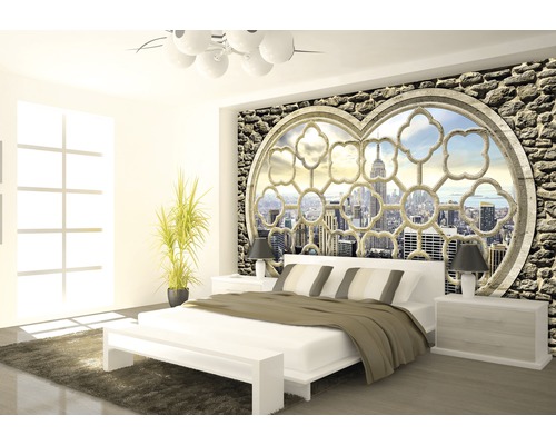 Helles Schlafzimmer mit Doppelbett und Wandtapete mit Steinen und Fensteransicht auf eine Stadt