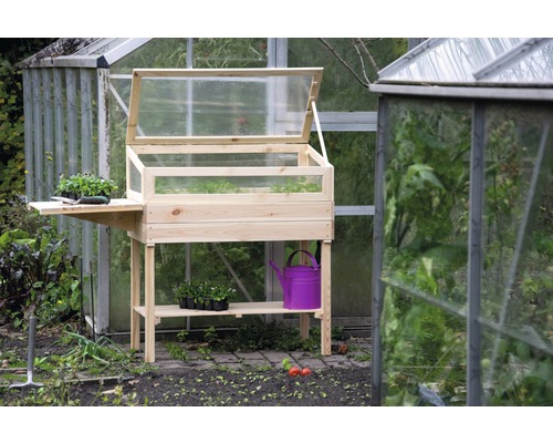 Jardinière sur pieds en bois avec étagère et serre devant une serre