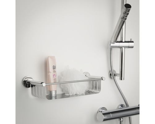 Étagère de douche en métal avec gel douche et éponge de bain fixée au mur.