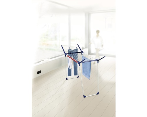 Séchoir à linge avec des vêtements suspendus dans une pièce lumineuse