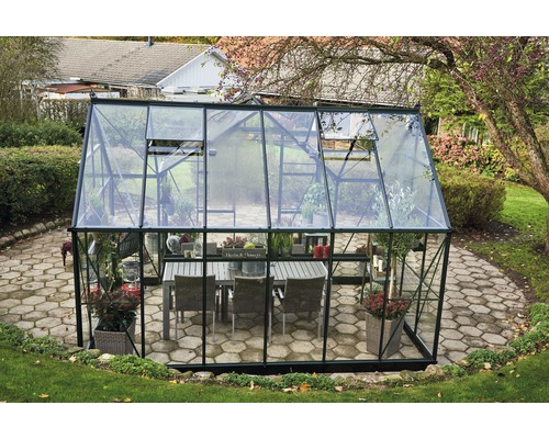 Serre avec table et plantes dans le jardin