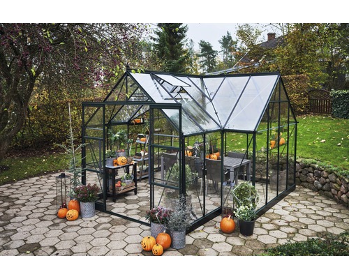 Serre de jardin avec table, chaises et décorations automnales.