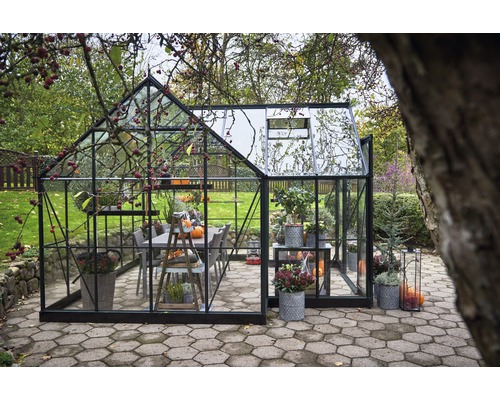 Serre avec plantes et meubles dans le jardin