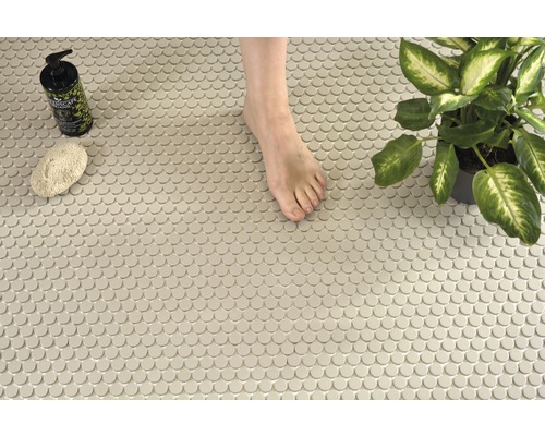 Szene mit runden Mosaikfliesen, einem Fuß, einer Pflanze, einem Schwamm und einer Seifenflasche