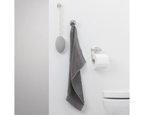 Salle de bains avec serviette, porte-papier toilette et savon sur le mur