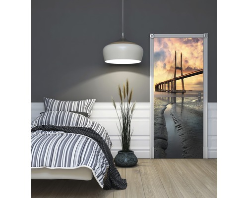 Chambre avec lit et poster de porte avec un motif de pont