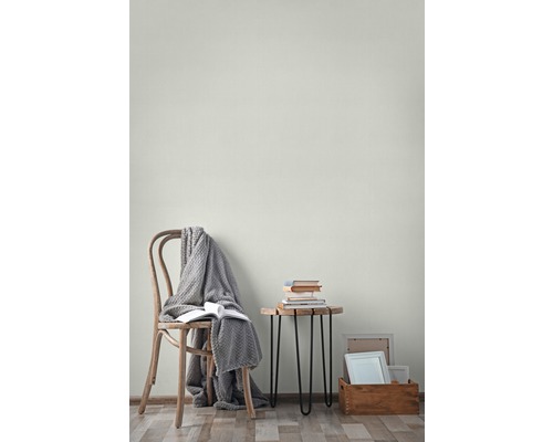 Salon avec chaise, couverture, livres, table d''appoint et cadres photo