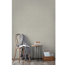 Pièce lumineuse avec papier peint intissé beige, chaise, table et décoration