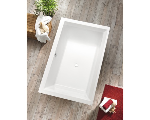 Baignoire rectangulaire dans une salle de bains avec plancher en bois