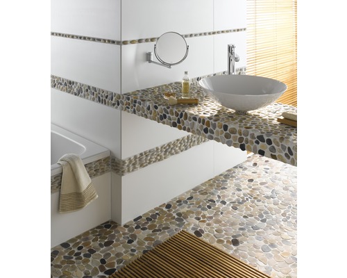 Badezimmer mit Waschbecken, Spiegel und Kieselsteinboden