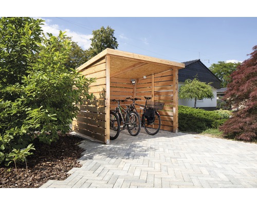 Abri à vélos ouvert en bois avec deux vélos sur un sol pavé