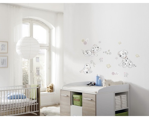 Chambre de bébé avec stickers muraux dalmatiens, table à langer et lit à barreaux