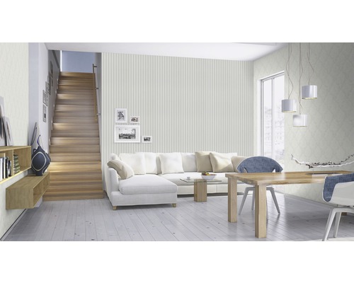 Espace de vie lumineux avec escalier, canapé, table à manger et papier peint à motifs