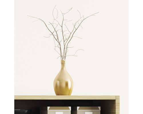 Vase décorative de couleur or avec des branches sur une étagère.