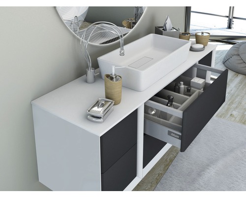 Salle de bain moderne avec lavabo, meuble sous-vasque et tiroir ouvert pour ranger les articles de toilette.