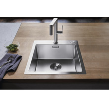 Spüle aus Edelstahl mit Wasserhahn auf einer Arbeitsplatte
