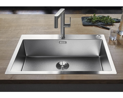 Évier en acier inoxydable avec robinet sur une surface en bois