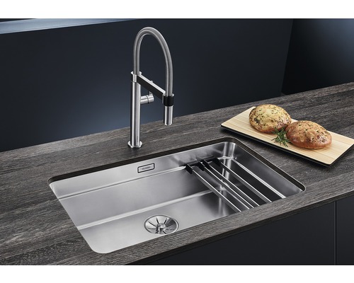 Évier en acier inoxydable avec robinet et planche à découper sur un plan de travail