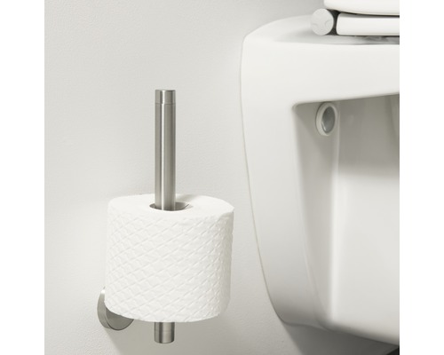 Porte-papier toilette en métal avec un rouleau de papier à côté d''une toilette