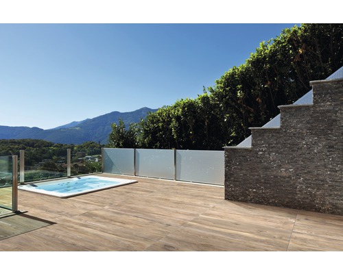 Terrasse mit Holzboden, Whirlpool und Steinmauer im Freien