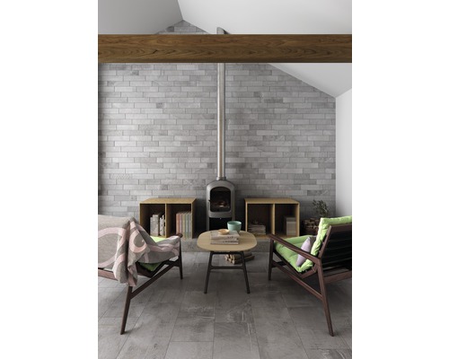 Wohnzimmer mit Steinkamin, Ziegelwand und Holzbalken