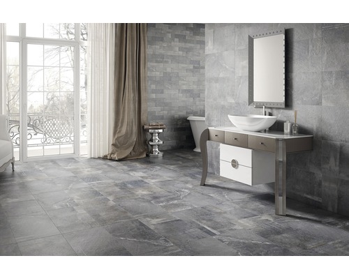 Modernes Badezimmer mit grauen Fliesen an Boden und Wand, Waschtisch mit Aufsatzwaschbecken und Spiegel