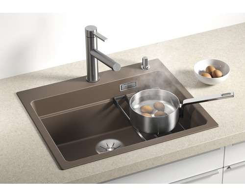 Spüle mit Wasserhahn, Spülmittelspender und Topf mit kochenden Eiern