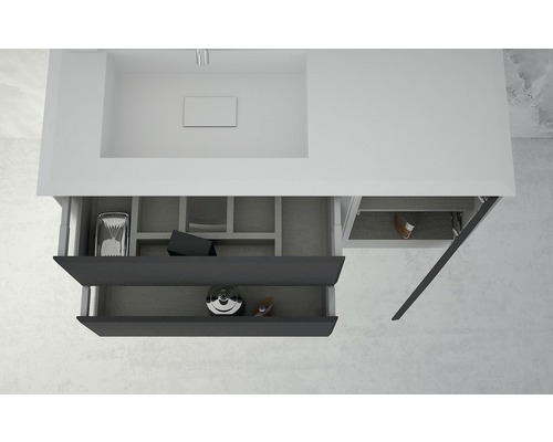 Meuble sous-lavabo avec tiroirs ouverts pour ranger les accessoires de salle de bain.