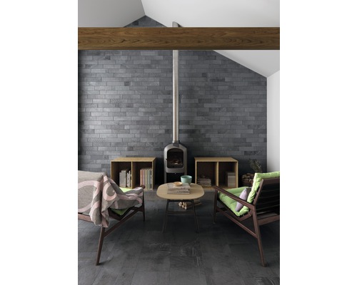 Wohnzimmer mit Kamin, zwei Sesseln, Couchtisch, gefliester Wand und gefliestem Boden