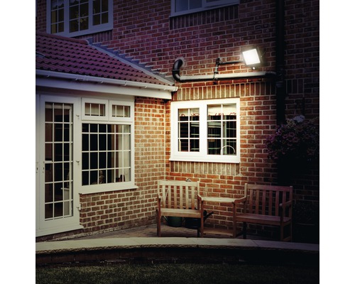 Aussenansicht eines Hauses mit Ziegelmauer und installierter LED-Aussenleuchte zur Beleuchtung des Gartens.