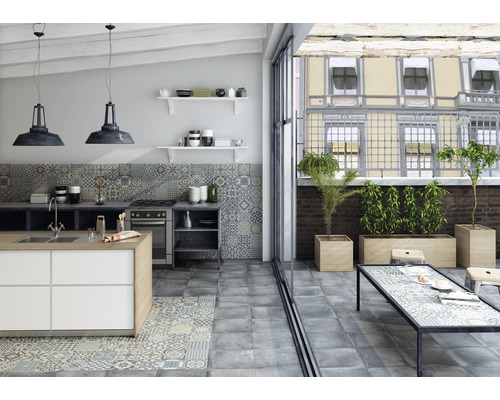 Cuisine claire avec îlot de cuisine, carrelage au sol, table de cuisine et plantes sur la terrasse