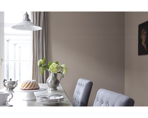 Scène de table à manger avec vaisselle, gâteau, vase de fleurs et suspension.