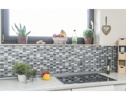 Scène de cuisine avec mur en mosaïque, rebord de fenêtre avec décoration et plaque de cuisson