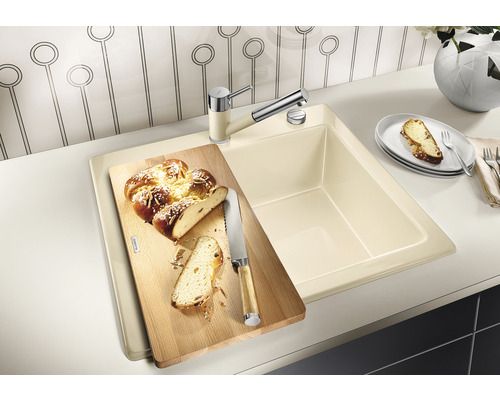 Évier de cuisine avec planche à découper et robinetterie sur un plan de travail