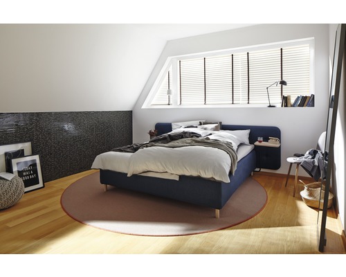 Chambre à coucher avec lit, tapis et éléments décoratifs dans un grenier lumineux