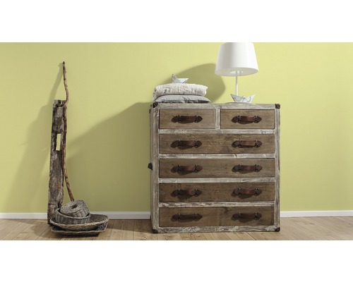 Commode en bois avec six tiroirs, objets de décoration et une lampe