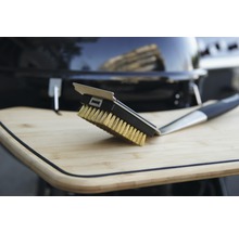 Grillbürste mit Messingborsten und Schaber auf einem Holztisch