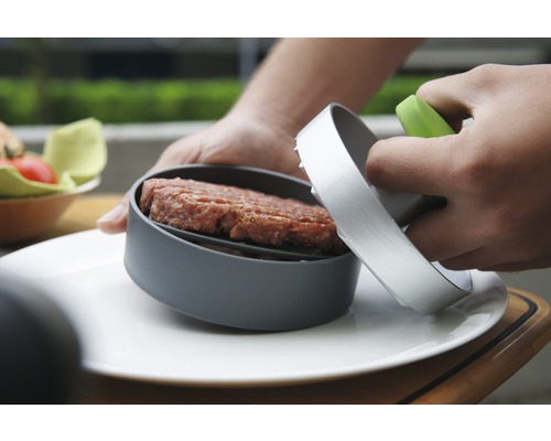 Burgerpresse mit Hackfleisch auf einem Teller