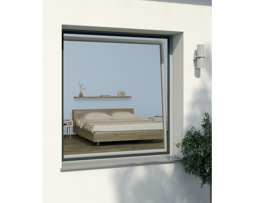 Blick durch ein Fenster mit Insektenschutzgitter auf ein Schlafzimmer